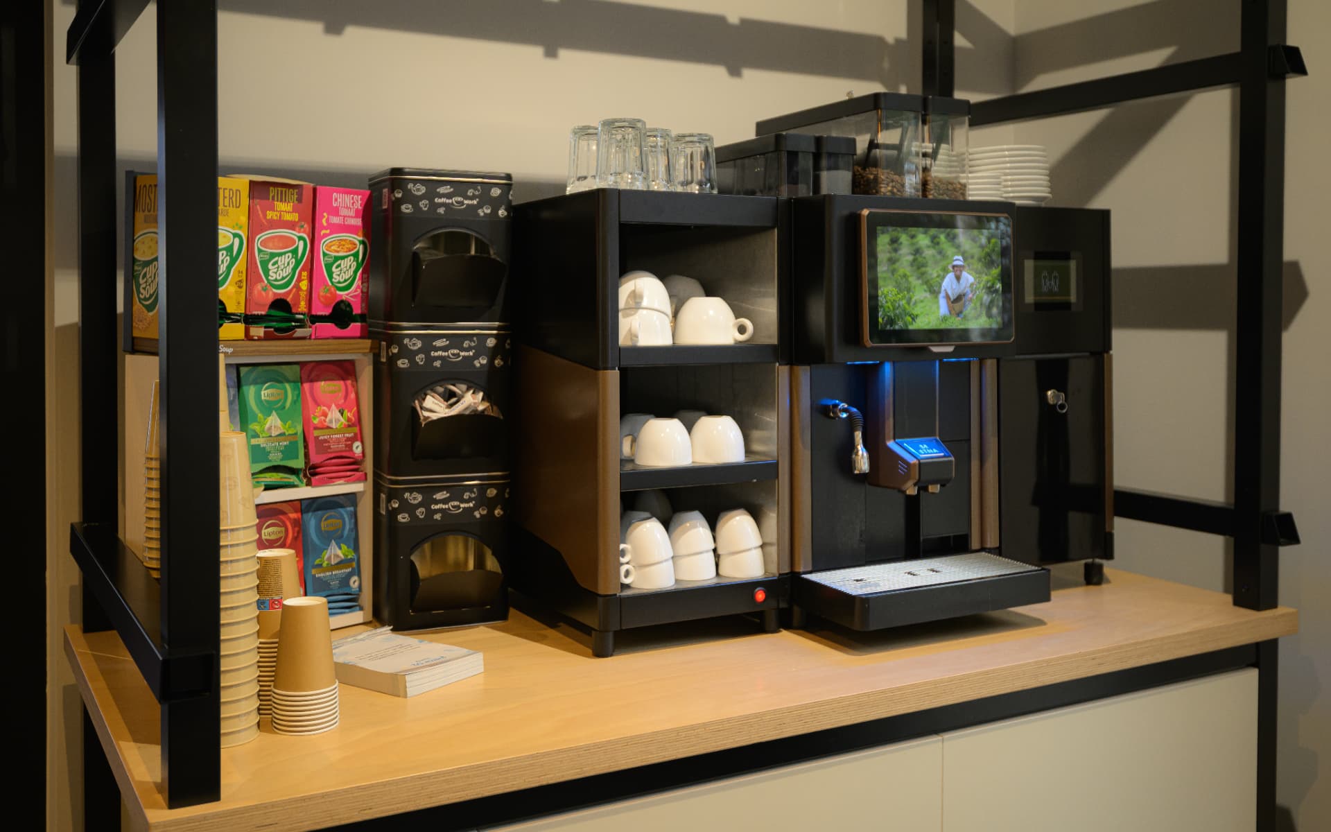 Koffiecorner op kantoor met machine, bekers en bijproducten